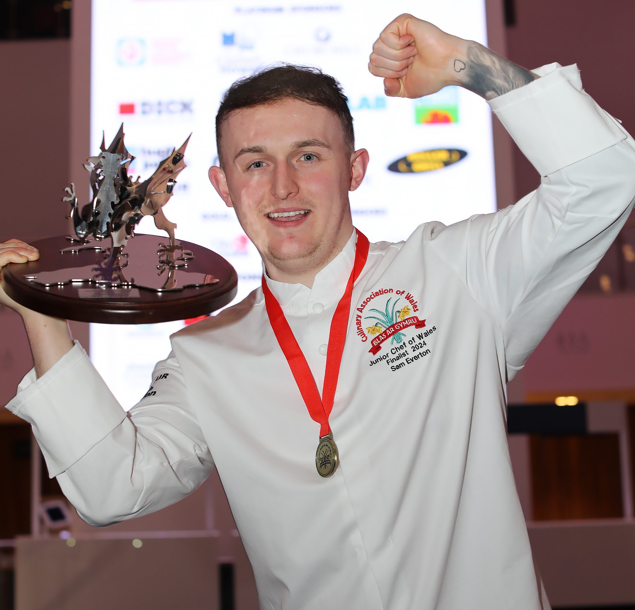 Sam Everton holds the dragon trophy aloft to celebrate winning the Junior Chef of Wales final.